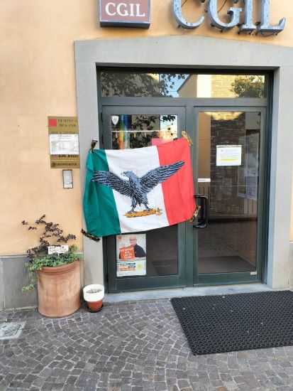 Bandiera con aquila su fascio littorio appesa davanti alla sede Cgil di Camucia